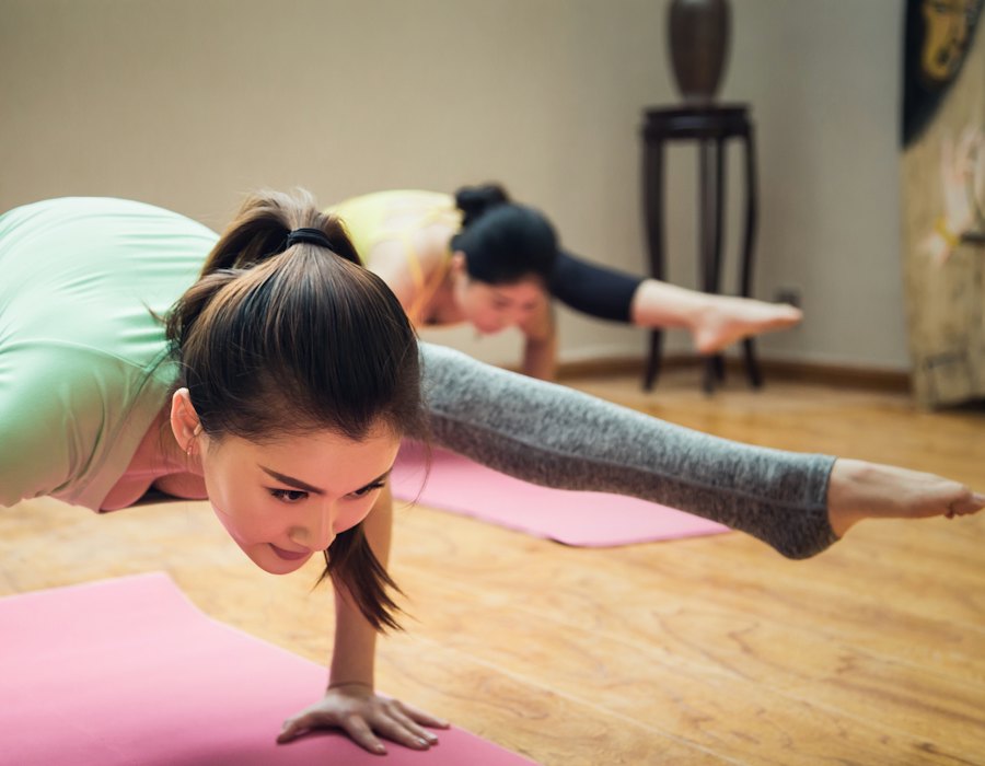Zwei Personen üben eine ruhige Bodenhaltung auf Yogamatten